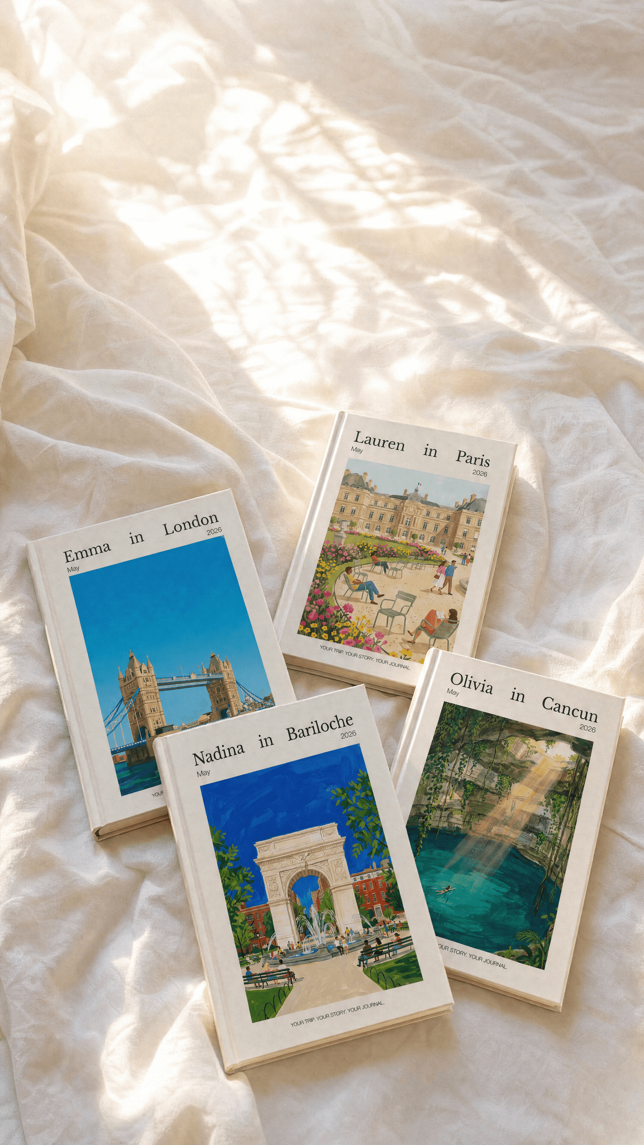 Four personalized travel journals laid out on a warm cream surface